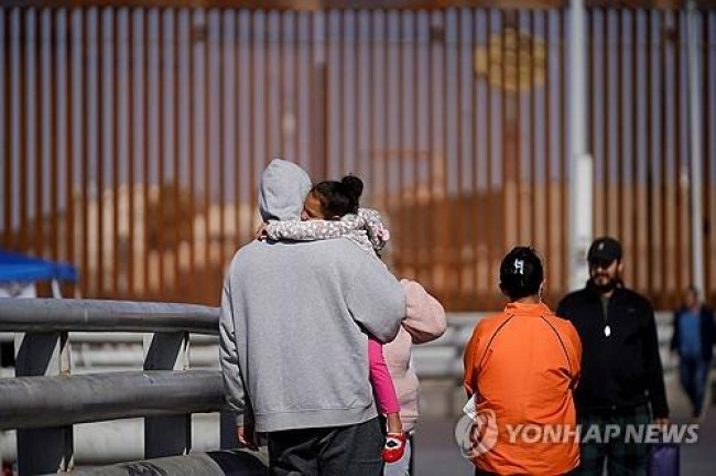 멕시코와 미국 국경 펜스 앞에서 대기 중인 망명 시도 가족